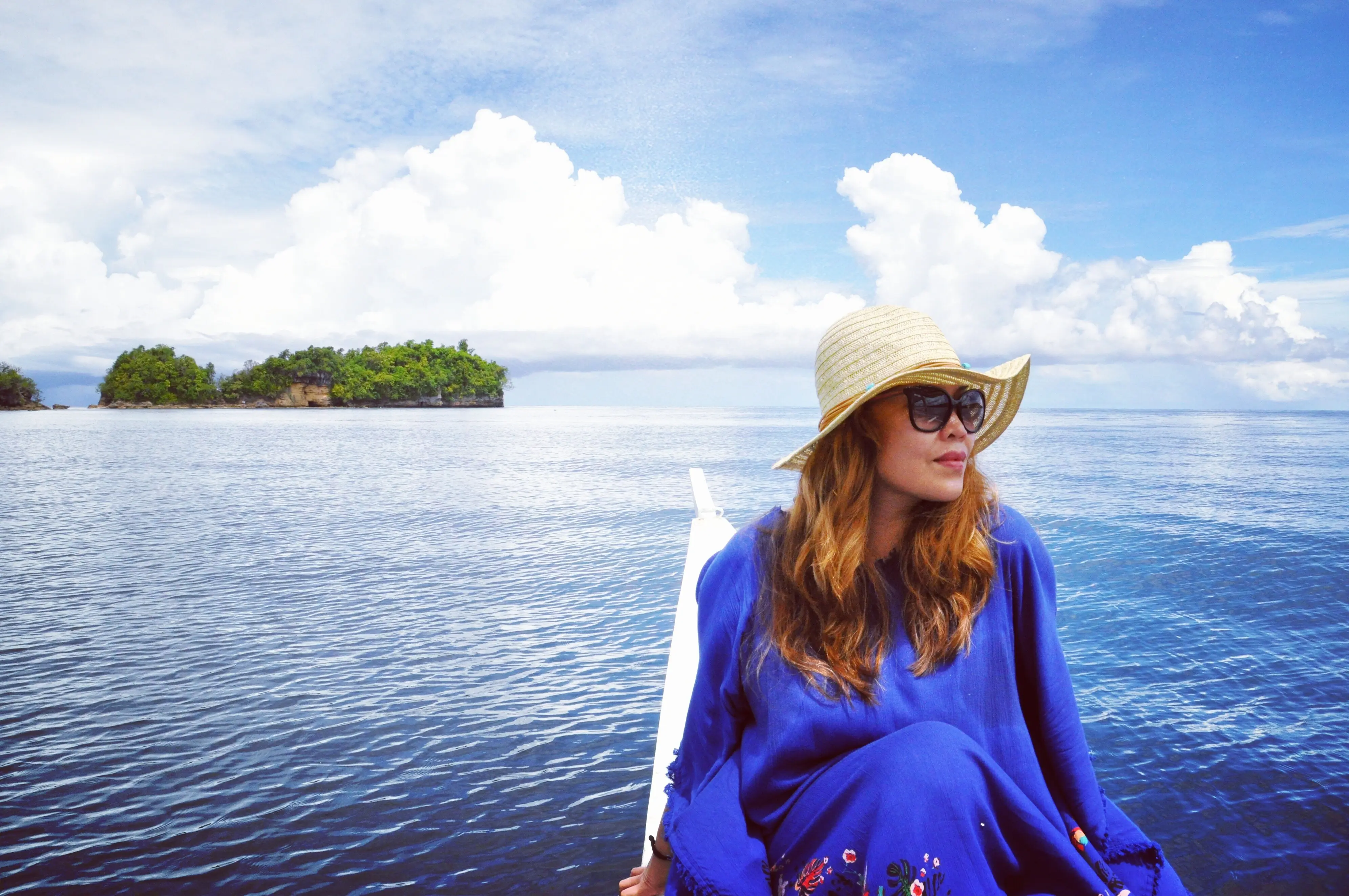 Schöne junge Frau vor dem Meer und dem Himmel